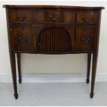 An early 20thC Regency design mahogany and satinwood string inlaid, serpentine front sideboard,