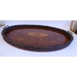 An Edwardian mahogany oval serving tray with a woven cane gallery, opposing brass bar handles,