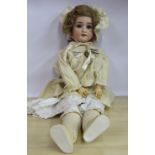 An early 20thC Simon & Halbig bisque head doll with painted features and weighted sleeping eyes,