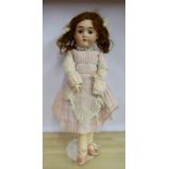 An early 20thC Max Handwerck bisque head doll with painted features and weighted sleeping eyes,