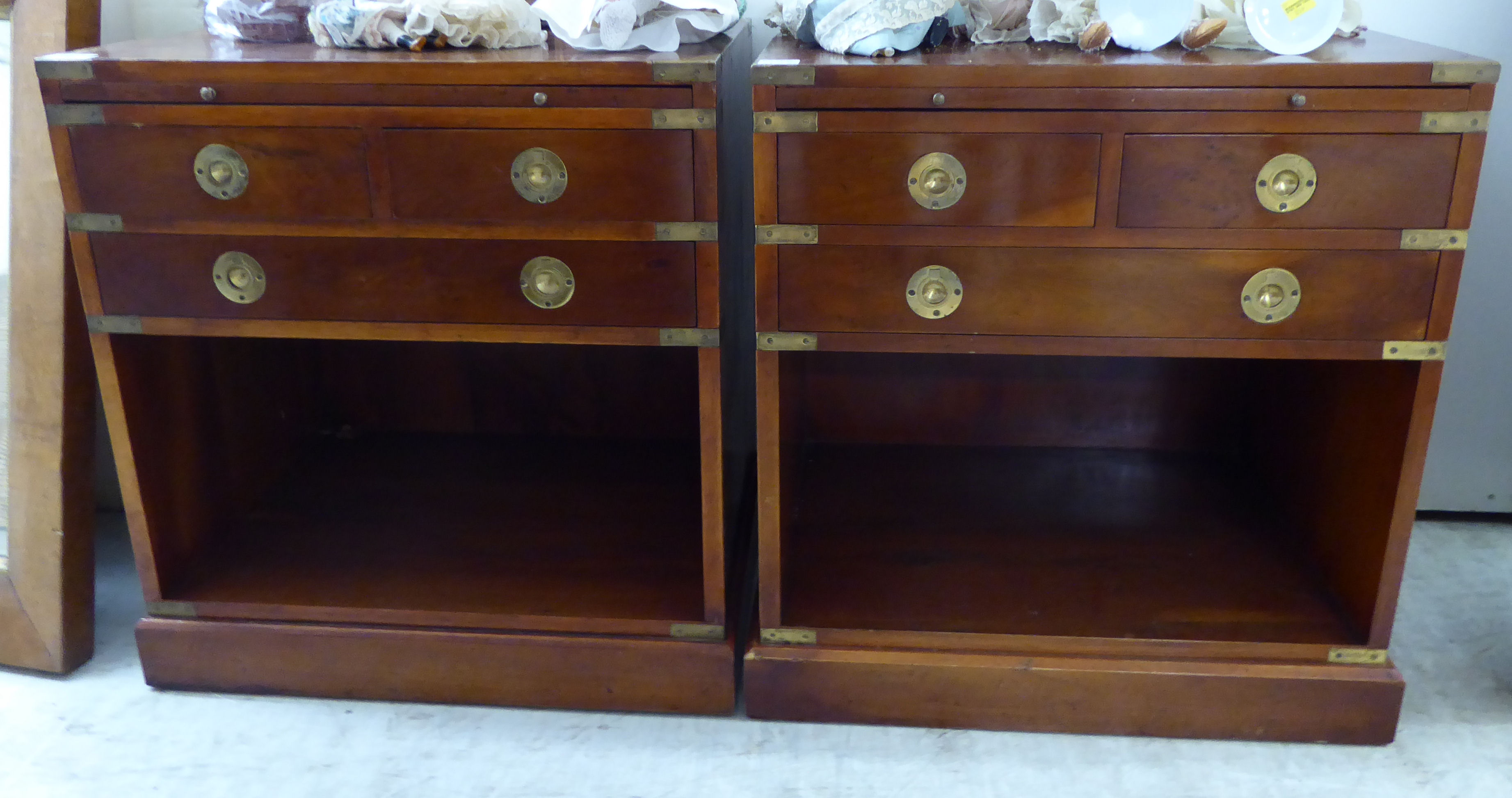 A pair of modern brass mounted yew wood bedside chests with a brushing slides,