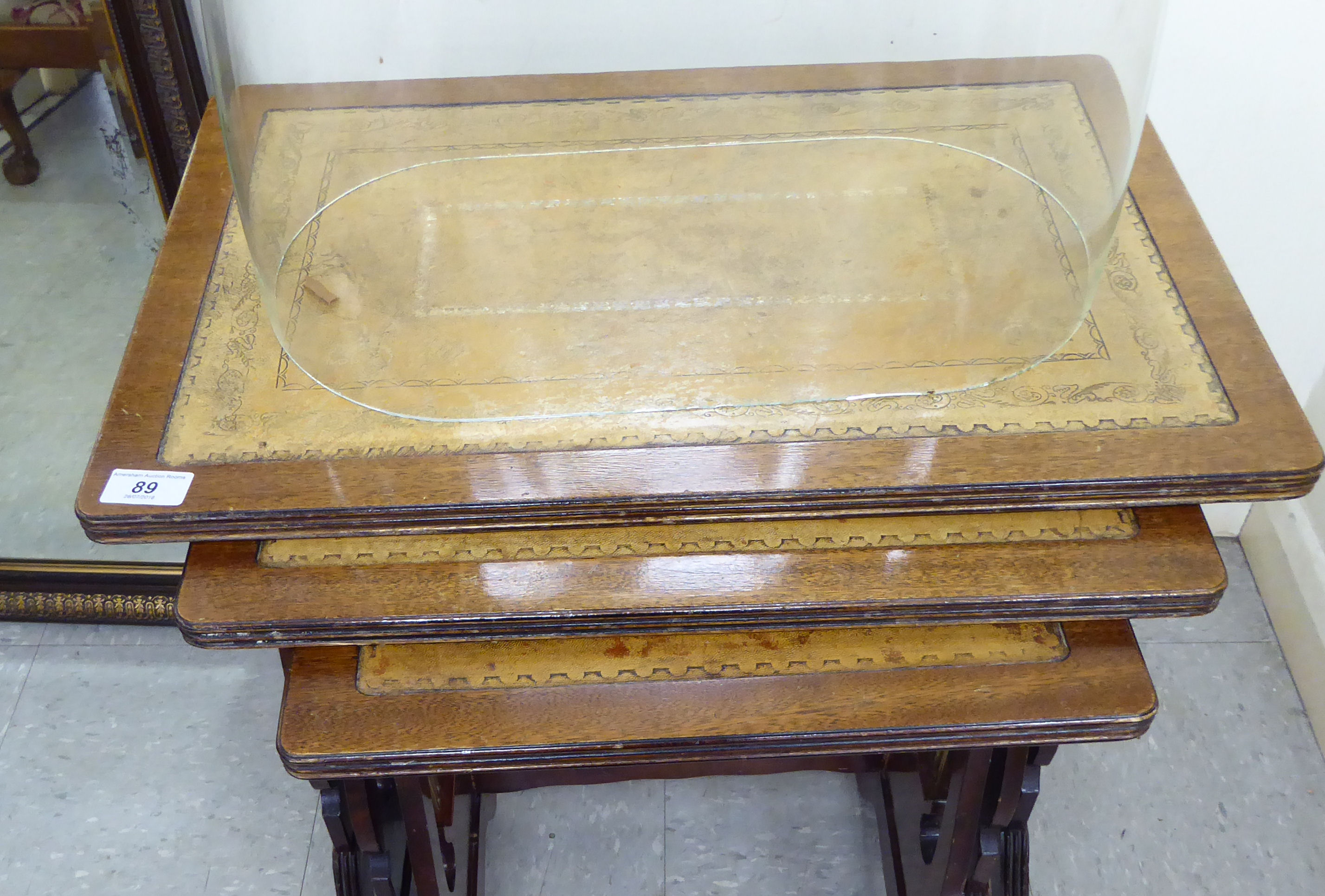 A modern nesting set of three mahogany finished tables with tooled old gold coloured hide surfaces, - Image 2 of 2