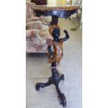 An early 20thC part stained and black lacquered pine, carved blackamoor pedestal stand,