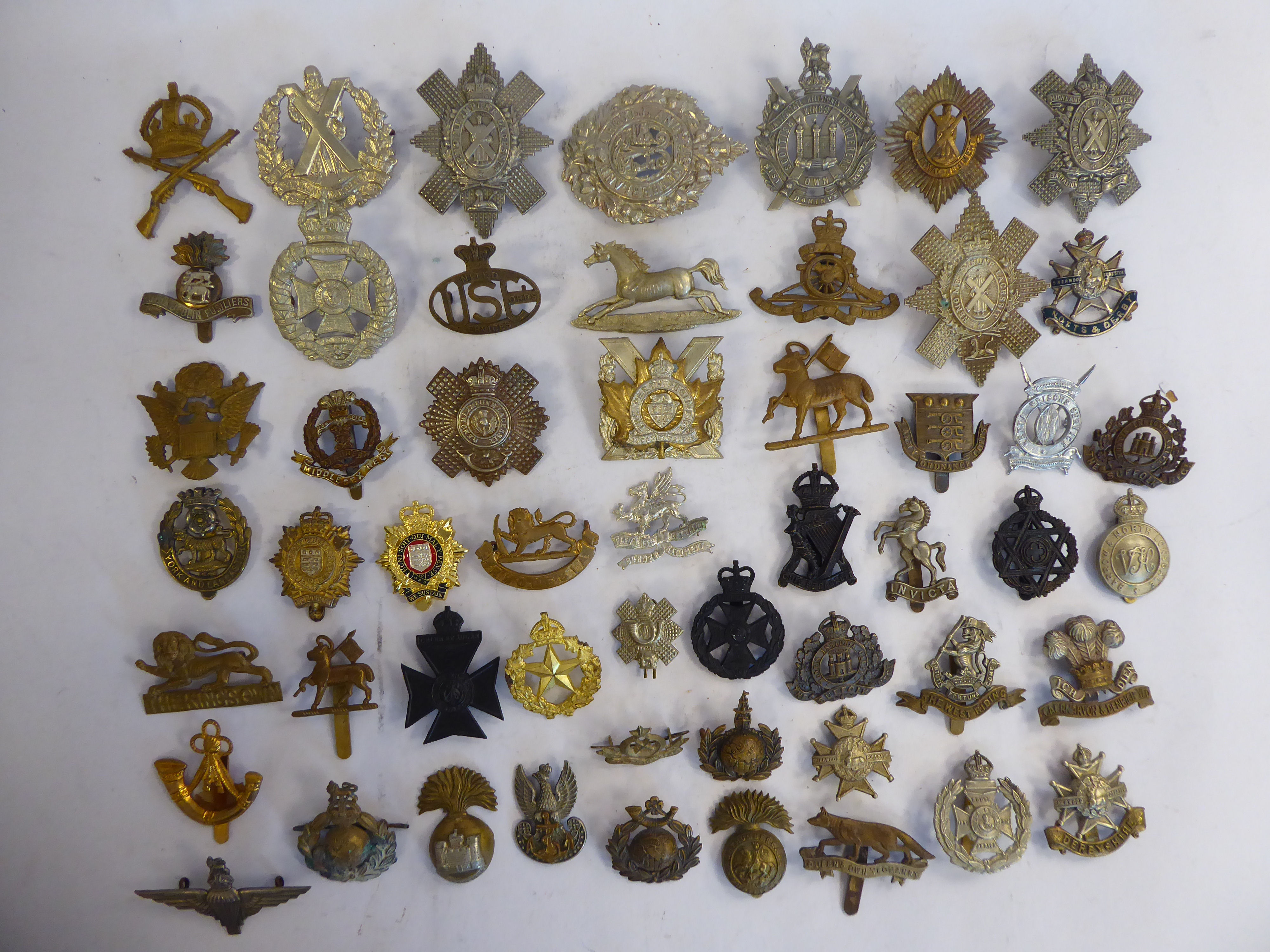 Approx fifty military cap badges and other insignia,