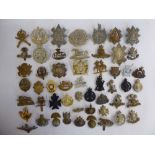 Approx fifty military cap badges and other insignia,