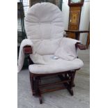 A modern mahogany framed Windsor style 'glider' armchair with a cushioned back and seat CA