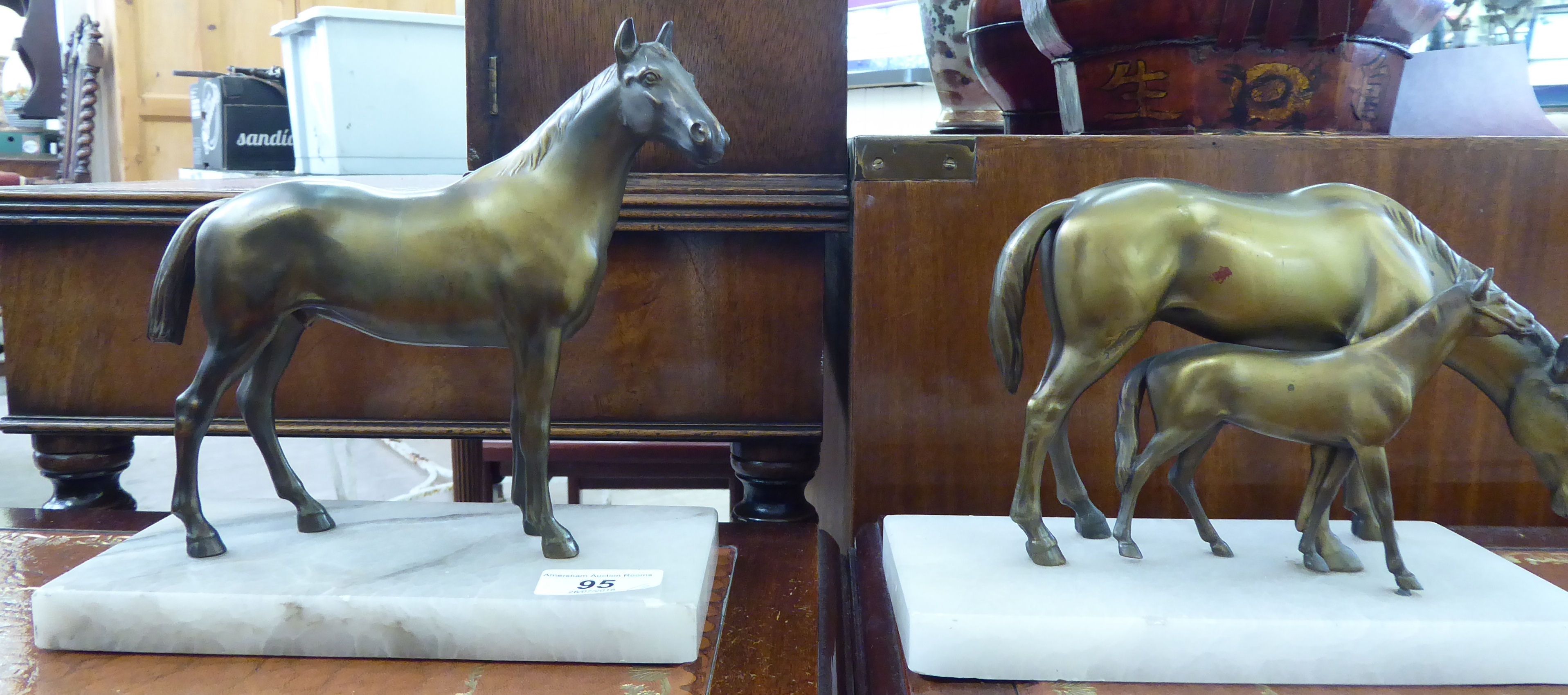 A pair of bronze finished metal equestrian models, a horse with a foal and a standing stallion,