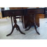 A pair of modern mahogany finished sofa style lamp tables with tooled and gilded hide surfaces,