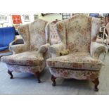 A pair of mid 20thC Queen Anne inspired wingback chairs with scrolled arms,