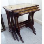 A modern nesting set of three mahogany finished tables with tooled old gold coloured hide surfaces,