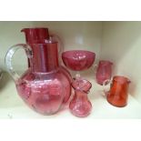 Early 20thC Cranberry glassware: to include two water jugs with drawn loop handles OS5