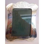 An Edwardian silver photograph frame with engraved floral and foliate scrolled ornament,