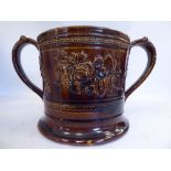 A mid 19thC treacle glazed earthenware 'oversize' loving cup with straight sides,