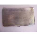 A silver folding cigarette case with engine turned decoration,