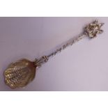 A silver presentation spoon with a shell design bowl,