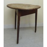 A late 18th/early 19thC country made oak cricket table, the planked top raised on chamfered,