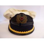 A World War II German Navy peaked cap with a pressed metal eagle and swastika