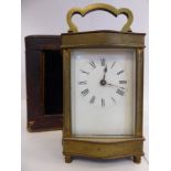 An early 20thC serpentine outlined lacquered brass cased carriage timepiece with bevelled glass