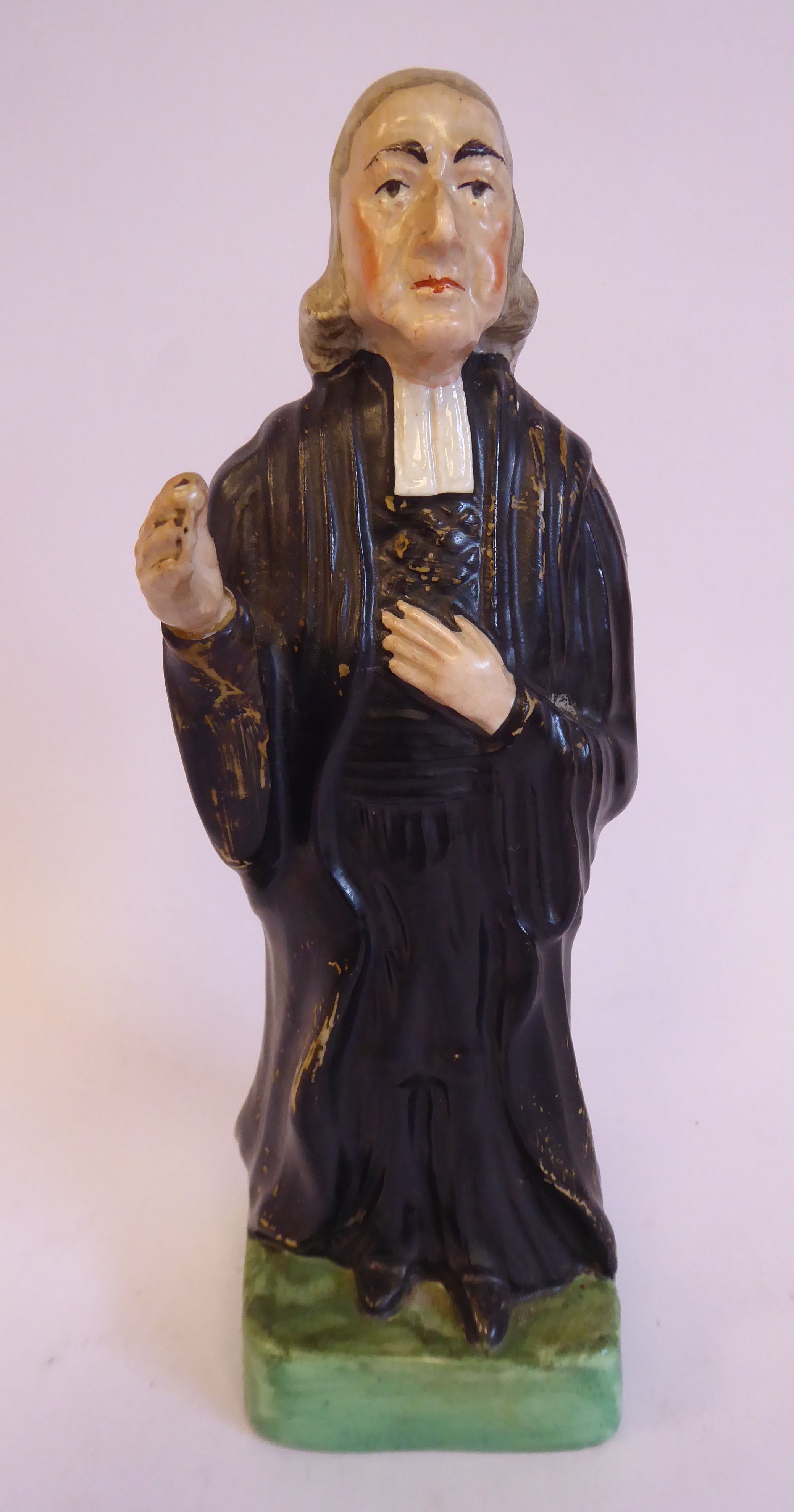 A 19thC Staffordshire pottery figure, John Wesley, wearing a black surplus and white cravat,