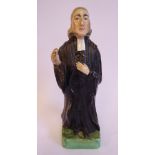 A 19thC Staffordshire pottery figure, John Wesley, wearing a black surplus and white cravat,