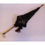 An Edwardian parasol with a black silk canopy, a bamboo shaft,