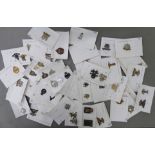 Approximately fifty-five military cap badges and other insignia,