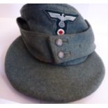 A World War II German Army ski cap with a cloth eagle and swastika and a pressed metal Edelweiss