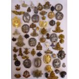 Approximately fifty-five military cap badges and other insignia,