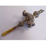 A baby's Edwardian silver rattle with six bells, embossed scrolls and other ornament,