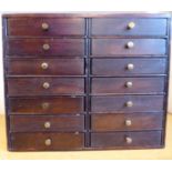 An early 20thC stained pine table-top collector's chest, comprising fourteen short drawers,