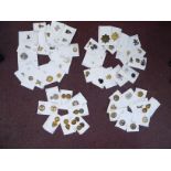 Approximately fifty-five military cap badges and other insignia,