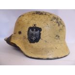 A World War II German Army steel helmet, in sand colour for desert use,