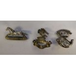 Three silver military cap badges, viz. The King's Liverpool Regt.