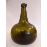 A late 18th/early 19thC semi-opaque dark green glass wine bottle of squat,