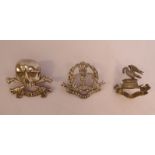 Three silver military cap badges, viz. The Middlesex Regt.
