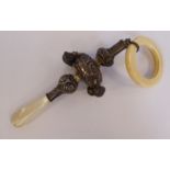 A baby's Victorian style silver rattle with four bells, embossed ornament,