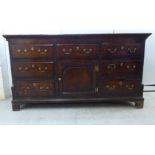 A mid 18thC crossbanded mahogany and oak dresser with a planked top,