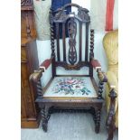 A 1920/30s carved and stained oak and beech framed open armchair,