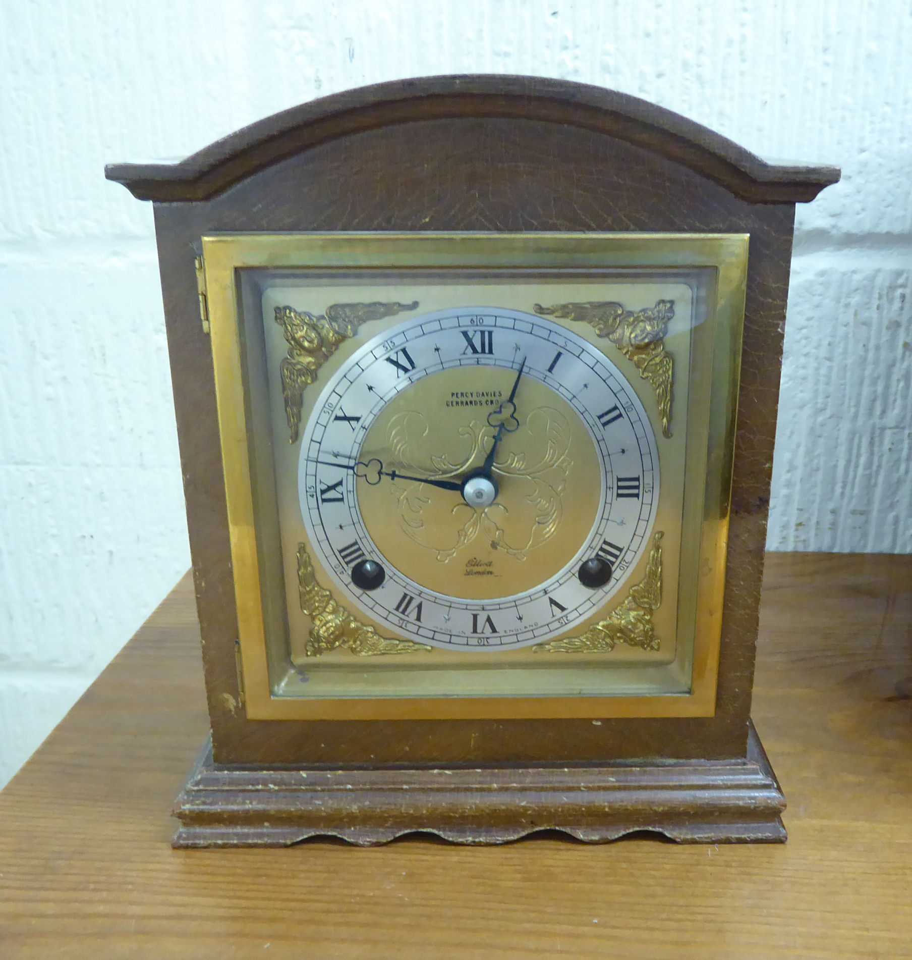 A mid 20thC mahogany finished bracket clock with a round arched top and straight sides;