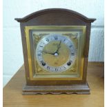 A mid 20thC mahogany finished bracket clock with a round arched top and straight sides;