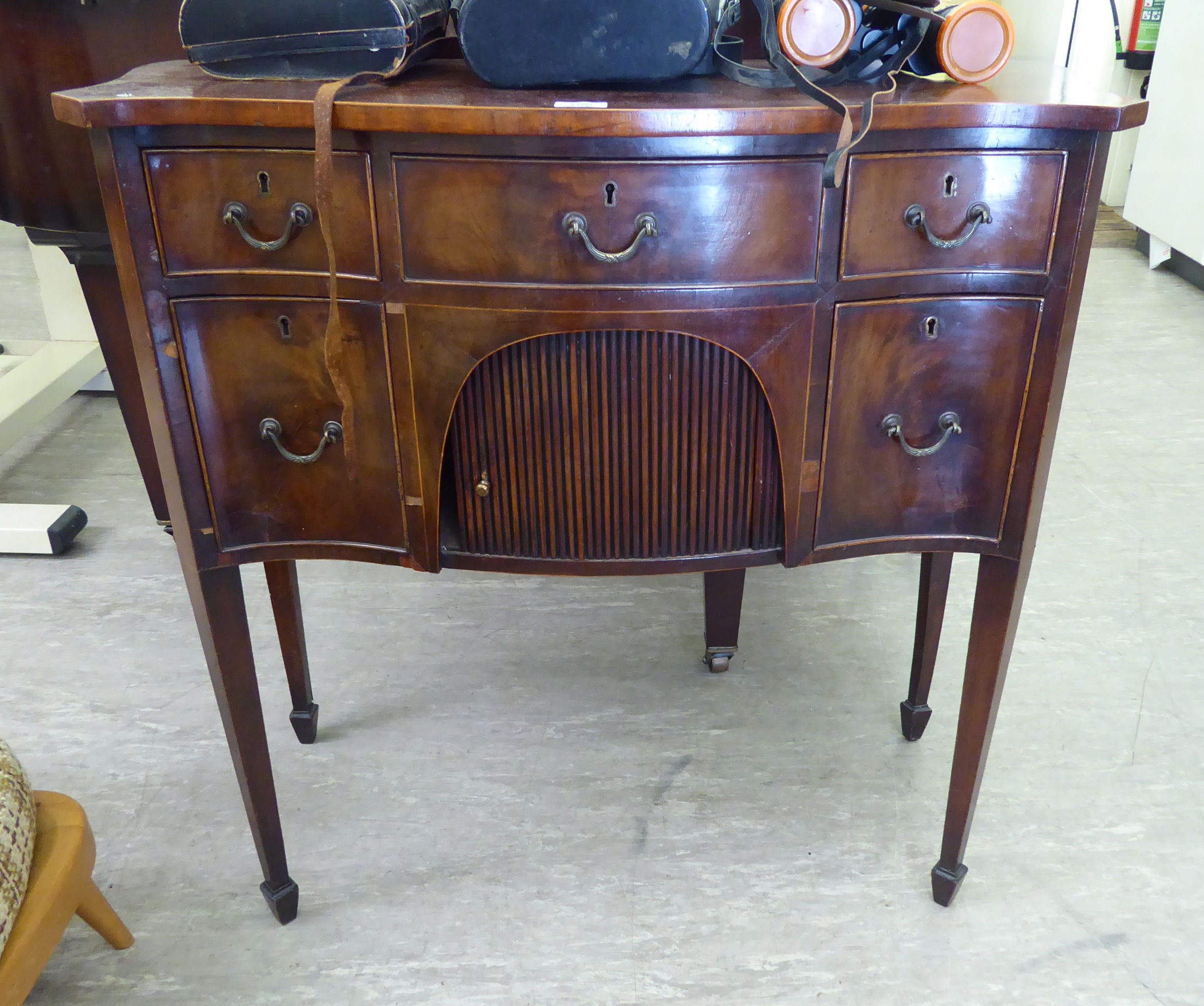 An early 20thC Regency design mahogany and satinwood string inlaid, serpentine front sideboard,