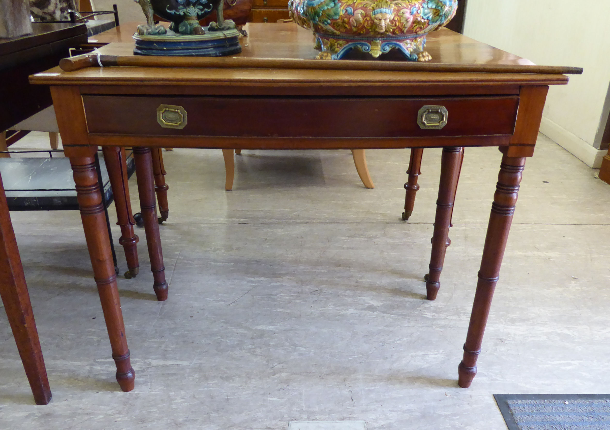 A mid 19thC mahogany bow front side table, the shallow frieze drawer with brass ring handles,