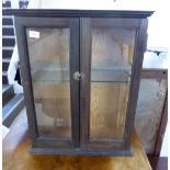 An early 20thC stained pine hanging display cabinet,