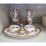 A 20thC Dresden china condiments set, decorated with pictorial vignettes and gilding,