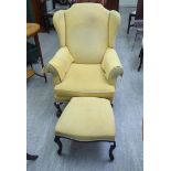 A lady's mid 20thC wingback chair, having scrolled arms,