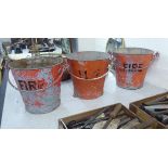 A set of three red painted and riveted galvanised iron fire buckets with swing handles BSR