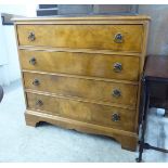 A mid 20thC walnut veneered four drawer chest with anodised iron ring handles,