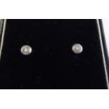 A pair of white metal rubover set diamond stud earrings 11