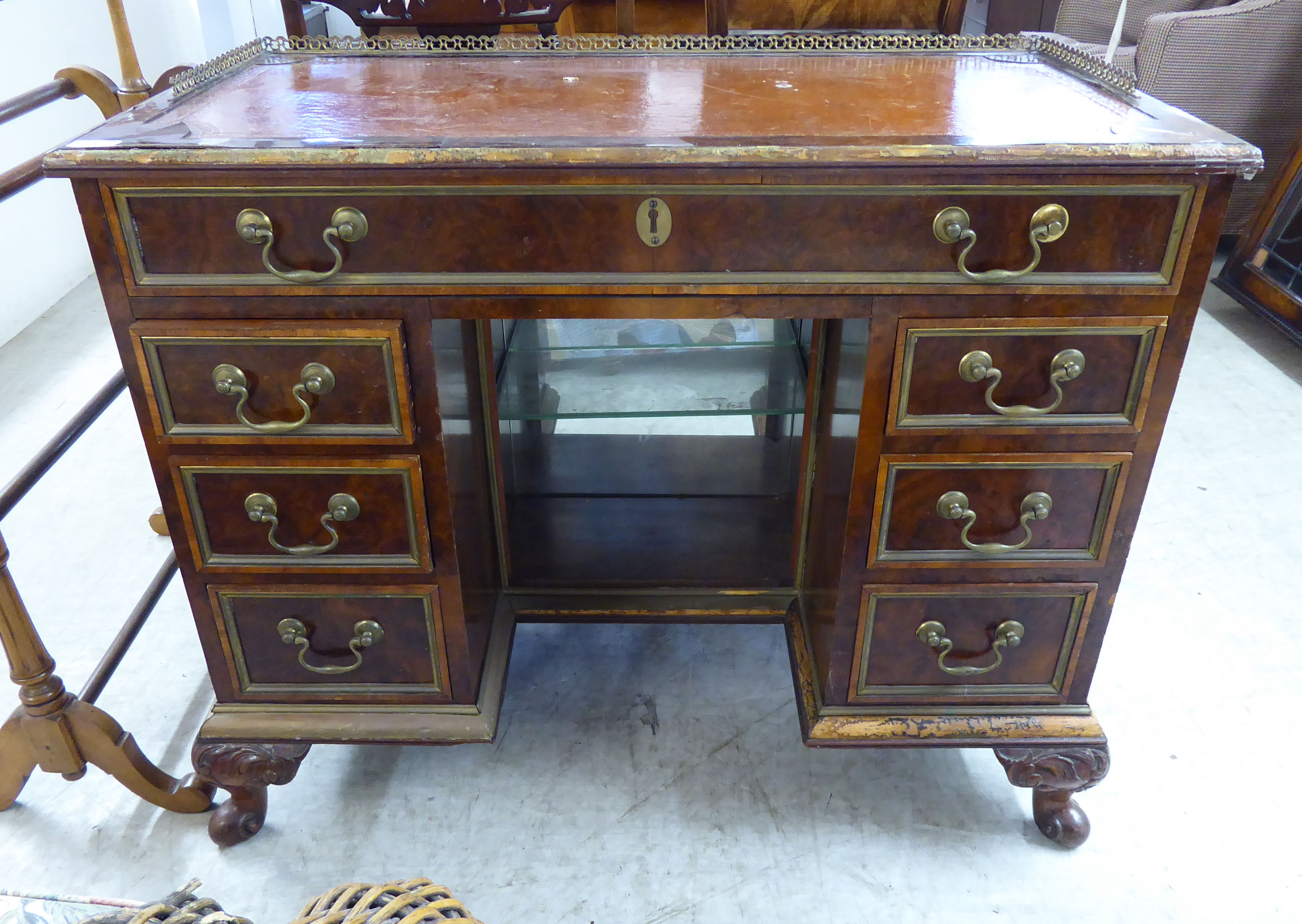 A 1930s burr walnut veneered twin pedestal desk, having a brass galleried border,