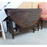 A George III stained oak drop leaf table, raised on baluster and block supports,
